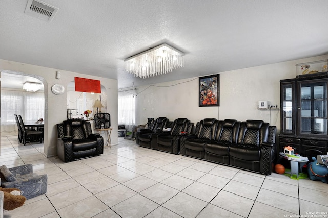1515 Agency, San Antonio, TX 78245 - home theater room featuring light tile patterned floors, healthy amount of natural light, a chandelier, and a textured ceiling