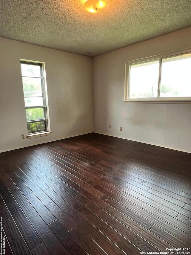 6014 White Cloud, San Antonio, TX 78238 - empty room featuring healthy amount of natural light, dark wood-type flooring, and a textured ceiling