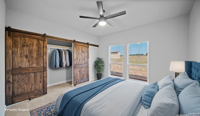 201 Lakeview Cir, La Vernia, TX 78121 - bedroom featuring a barn door, carpet flooring, ceiling fan, and baseboards