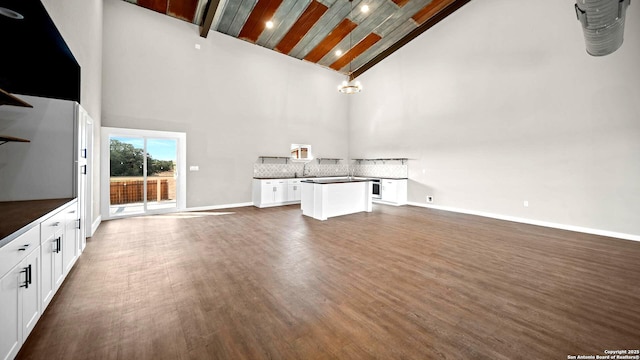 201 Lakeview Cir, La Vernia, TX 78121 - unfurnished living room with dark wood finished floors, high vaulted ceiling, and baseboards