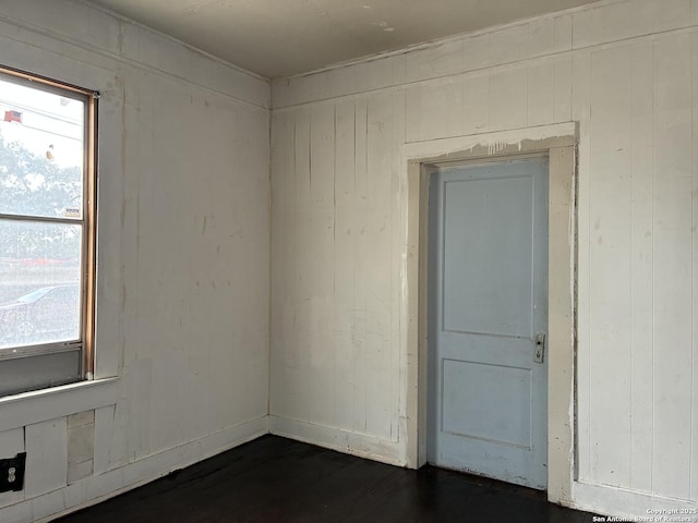 402 Pruitt, San Antonio, TX 78204 - unfurnished room with healthy amount of natural light, wood walls, and dark wood-type flooring