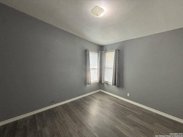 527 Artemis, San Antonio, TX 78218 - unfurnished room with dark wood-style flooring, baseboards, vaulted ceiling, and a textured ceiling