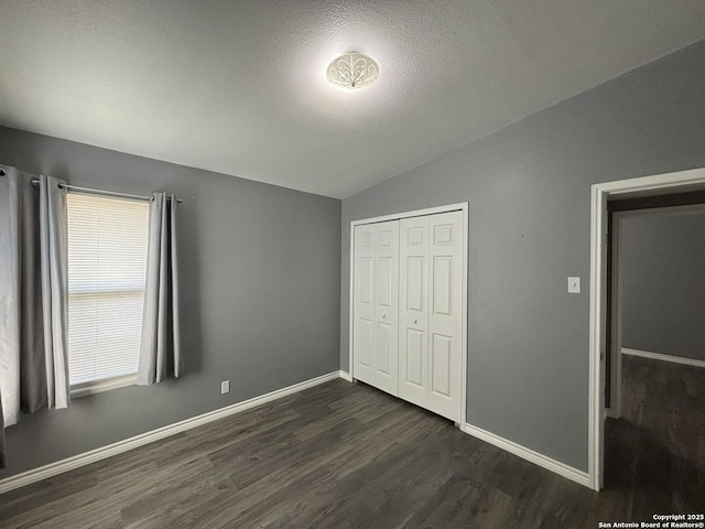 527 Artemis, San Antonio, TX 78218 - unfurnished bedroom with lofted ceiling, dark wood-type flooring, baseboards, and a closet