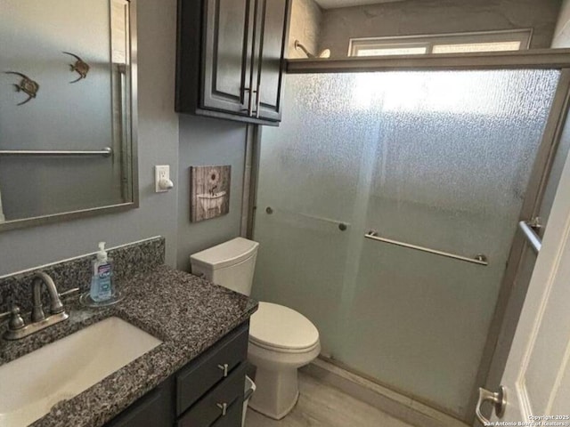 527 Artemis, San Antonio, TX 78218 - bathroom featuring vanity, toilet, a shower with shower door, and wood finished floors