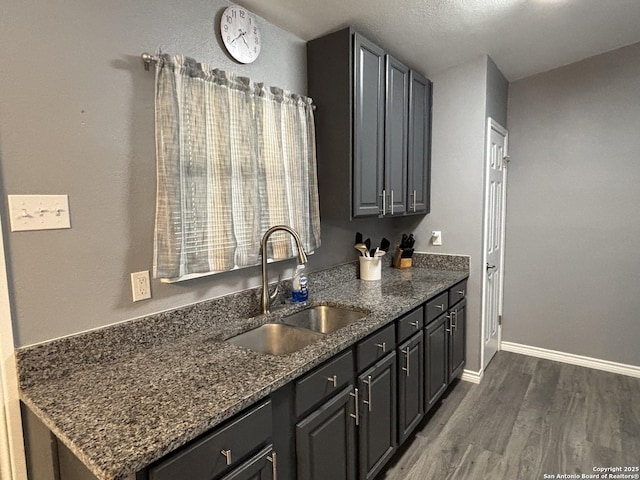 527 Artemis, San Antonio, TX 78218 - kitchen featuring a sink, dark wood-style flooring, dark stone counters, and baseboards