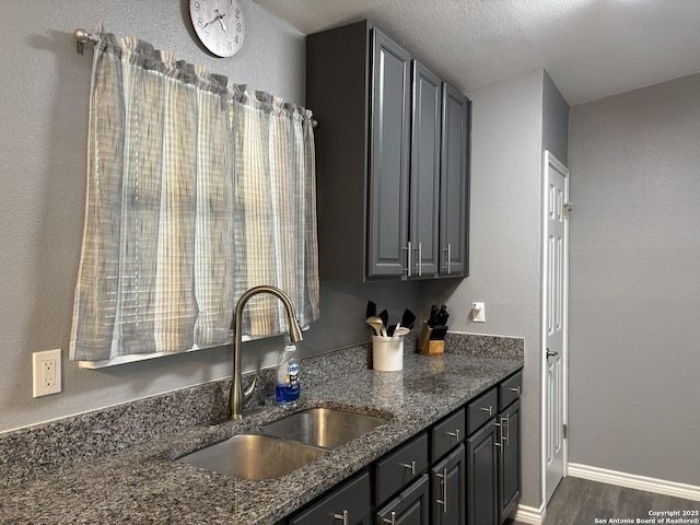 527 Artemis, San Antonio, TX 78218 - kitchen featuring a sink, dark stone counters, dark wood-type flooring, and baseboards