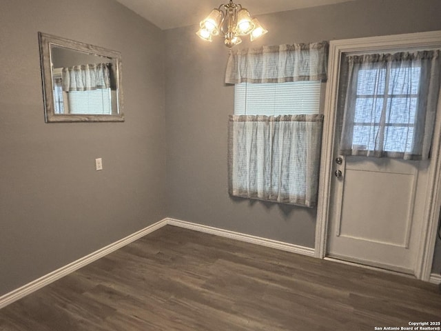 527 Artemis, San Antonio, TX 78218 - unfurnished dining area featuring dark wood-type flooring, a chandelier, and baseboards