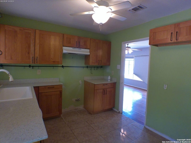 427 Olney, San Antonio, TX 78209 - kitchen featuring under cabinet range hood, a sink, a ceiling fan, light tile patterned flooring, and brown cabinets