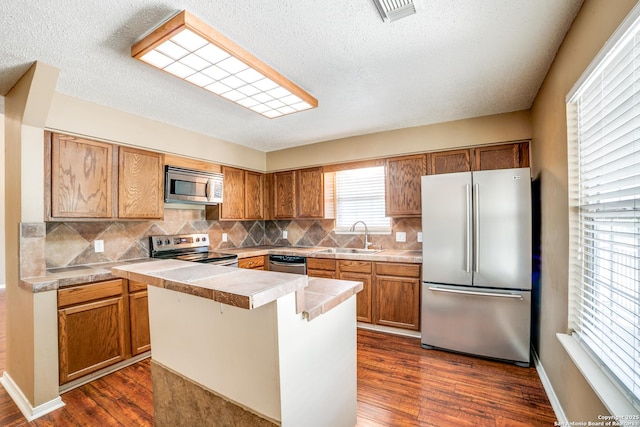 756 County Road 245, Hondo, TX 78861 - kitchen with appliances with stainless steel finishes, a sink, dark wood finished floors, tasteful backsplash, and a textured ceiling