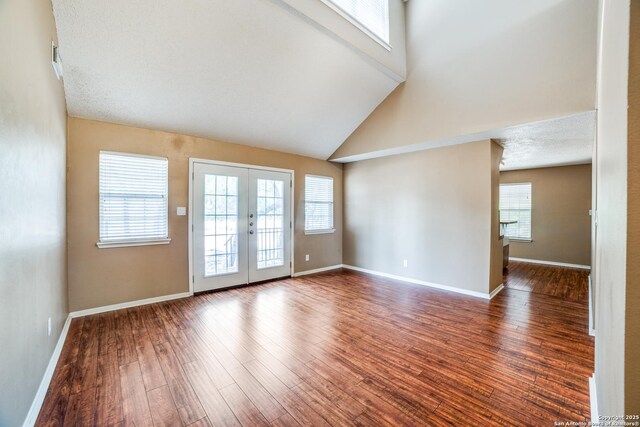 756 County Road 245, Hondo, TX 78861 - empty room featuring french doors, wood finished floors, high vaulted ceiling, and baseboards