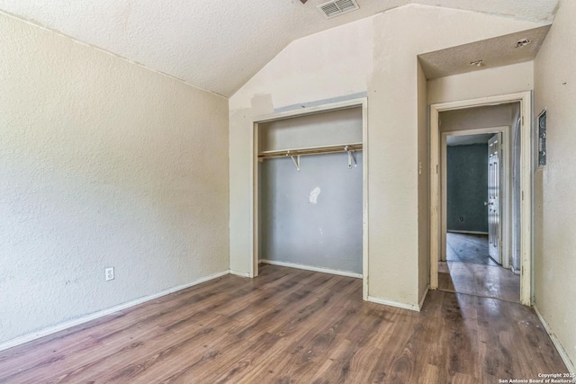2514 Christian, San Antonio, TX 78222 - unfurnished bedroom with lofted ceiling, wood finished floors, a textured wall, a closet, and a textured ceiling