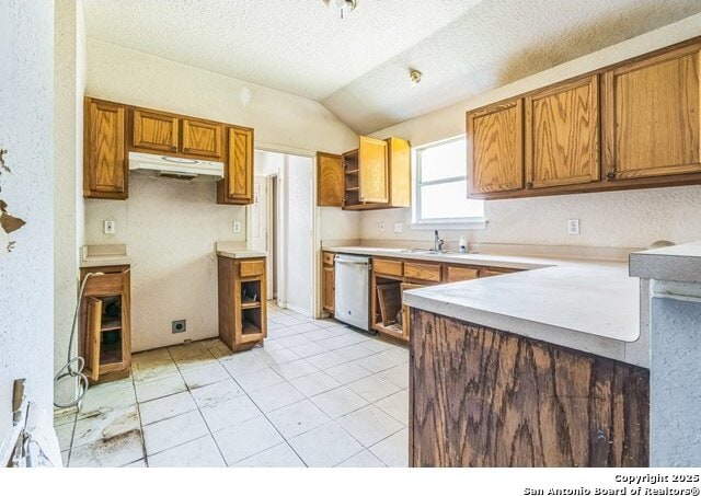 2514 Christian, San Antonio, TX 78222 - kitchen featuring dishwasher, under cabinet range hood, vaulted ceiling, brown cabinetry, and a sink