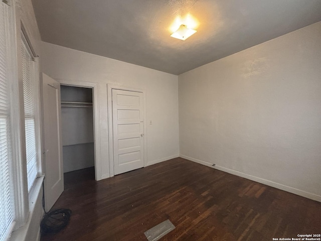 1502 W Woodlawn, San Antonio, TX 78201 - unfurnished bedroom featuring dark wood-style flooring, multiple windows, and baseboards