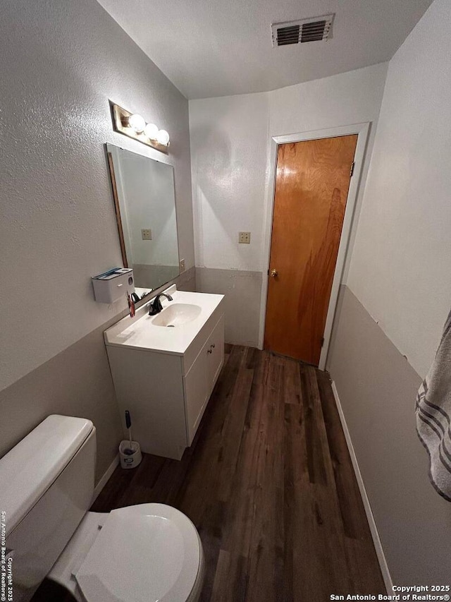 314 US Highway 57, La Pryor, TX 78872 - bathroom with wood finished floors, toilet, and vanity