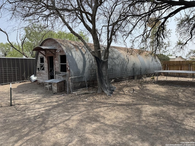 314 US Highway 57, La Pryor, TX 78872 - rear view of property featuring stone siding, an outbuilding, and a trampoline