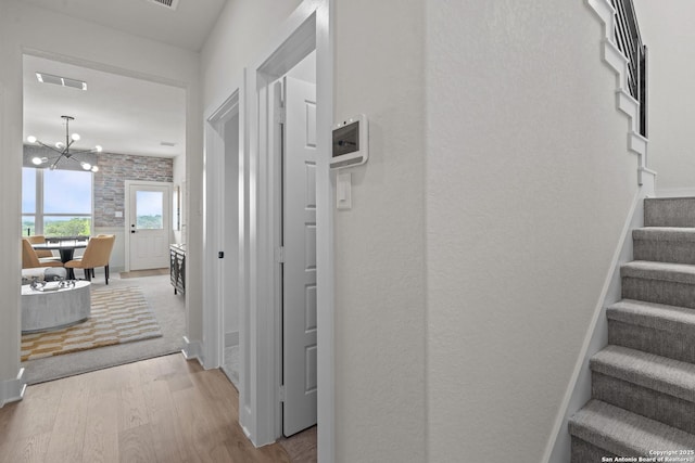 20675 Huebner Rd, San Antonio, TX 78258 - corridor with wood finished floors, stairway, a chandelier, and baseboards