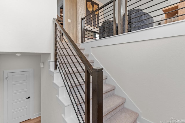 20675 Huebner Rd, San Antonio, TX 78258 - stairs featuring a towering ceiling, baseboards, and wood finished floors