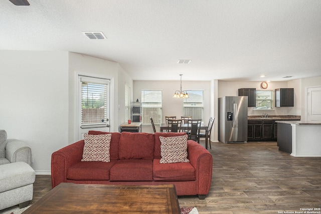 14506 Tundra Swan, San Antonio, TX 78253 - living room with dark wood finished floors, a chandelier, baseboards, and a textured ceiling