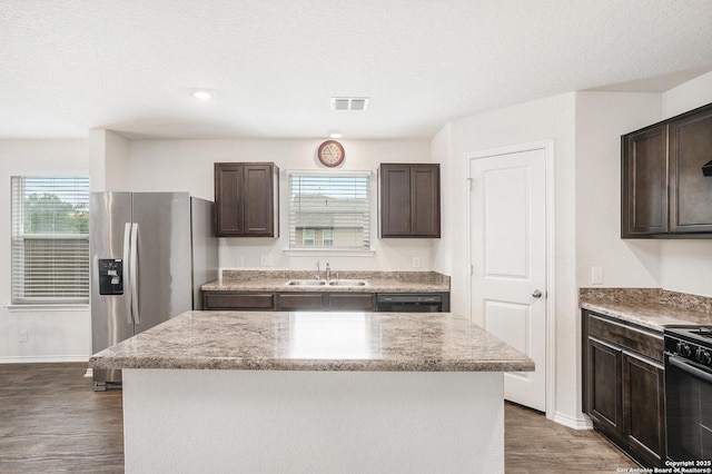 14506 Tundra Swan, San Antonio, TX 78253 - kitchen featuring black appliances, dark brown cabinetry, a sink, wood finished floors, and light stone counters
