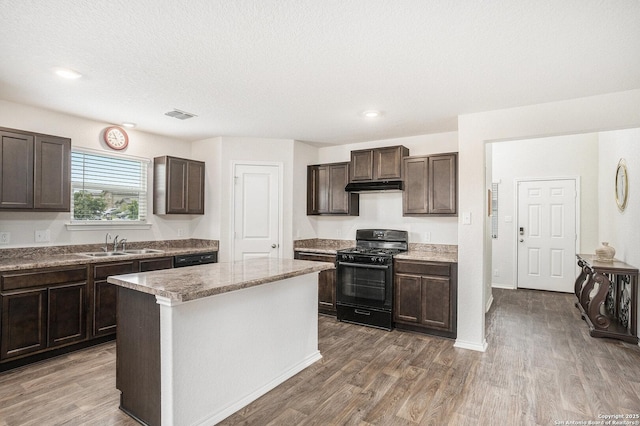 14506 Tundra Swan, San Antonio, TX 78253 - kitchen with black appliances, under cabinet range hood, dark brown cabinetry, a sink, and wood finished floors