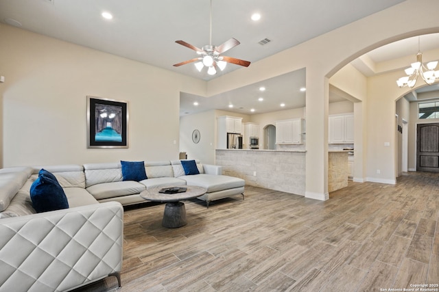 7938 Cibolo, Boerne, TX 78015 - living area with arched walkways, light wood finished floors, ceiling fan, a chandelier, and recessed lighting