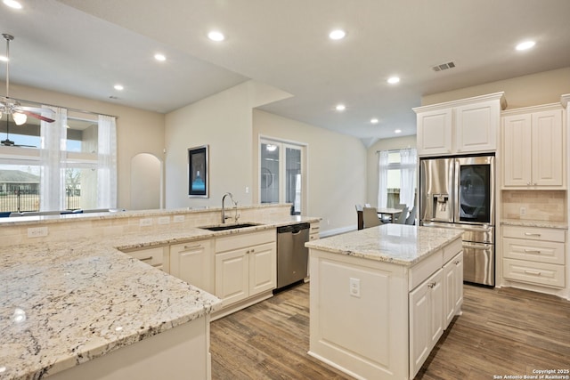 7938 Cibolo, Boerne, TX 78015 - kitchen featuring appliances with stainless steel finishes, a sink, decorative backsplash, a ceiling fan, and wood finished floors