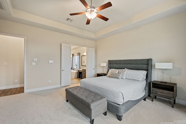 7938 Cibolo, Boerne, TX 78015 - bedroom featuring baseboards, light carpet, ensuite bath, a tray ceiling, and a ceiling fan