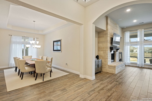 7938 Cibolo, Boerne, TX 78015 - dining area with wood finished floors, baseboards, arched walkways, a chandelier, and a fireplace