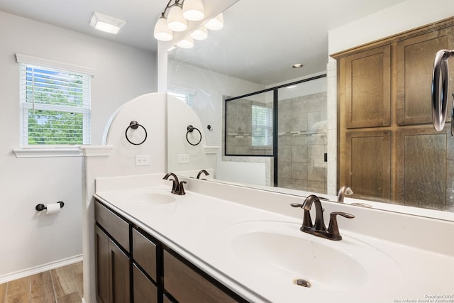 11423 Roadrunner, San Antonio, TX 78245 - bathroom featuring double vanity, wood finished floors, baseboards, a stall shower, and a chandelier