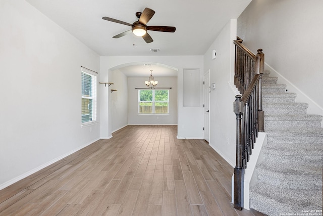 11423 Roadrunner, San Antonio, TX 78245 - unfurnished living room featuring arched walkways, a chandelier, stairway, wood finished floors, and a ceiling fan
