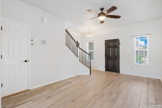 11423 Roadrunner, San Antonio, TX 78245 - foyer entrance with light wood-style flooring, stairway, a ceiling fan, and baseboards