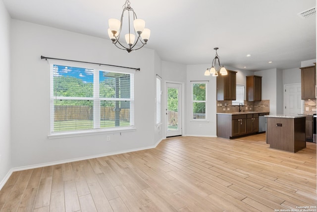 11423 Roadrunner, San Antonio, TX 78245 - kitchen with a chandelier, decorative backsplash, light wood-type flooring, baseboards, and recessed lighting