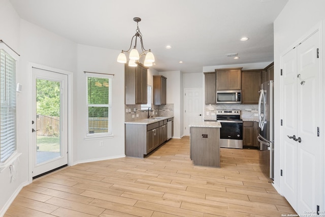 11423 Roadrunner, San Antonio, TX 78245 - kitchen with stainless steel appliances, light wood-type flooring, tasteful backsplash, a center island, and recessed lighting