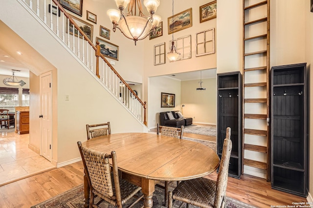 1802 Fallow Run, San Antonio, TX 78248 - dining room featuring stairway, baseboards, a chandelier, a high ceiling, and light wood-style floors