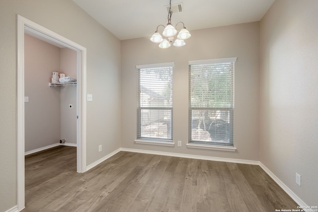543 Willow Grove Dr, San Antonio, TX 78245 - unfurnished dining area featuring wood finished floors, a chandelier, and baseboards