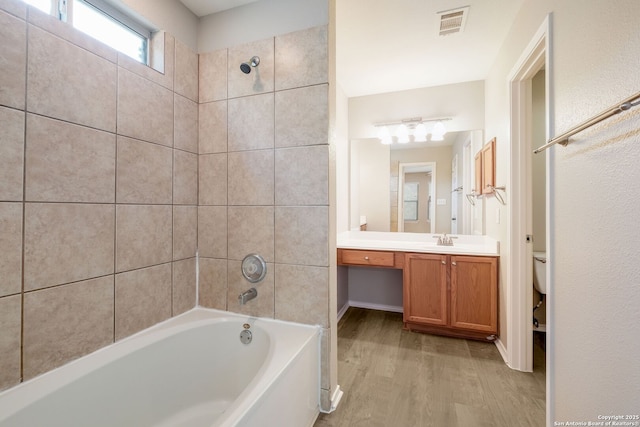543 Willow Grove Dr, San Antonio, TX 78245 - bathroom featuring wood finished floors, vanity, toilet, and tub / shower combination