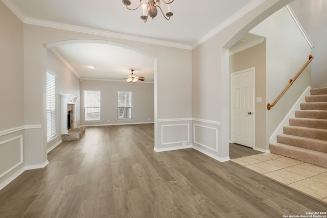 543 Willow Grove Dr, San Antonio, TX 78245 - unfurnished living room with arched walkways, wood finished floors, stairs, and crown molding