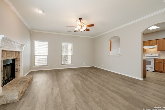 543 Willow Grove Dr, San Antonio, TX 78245 - unfurnished living room featuring ceiling fan, crown molding, a brick fireplace, light wood finished floors, and baseboards