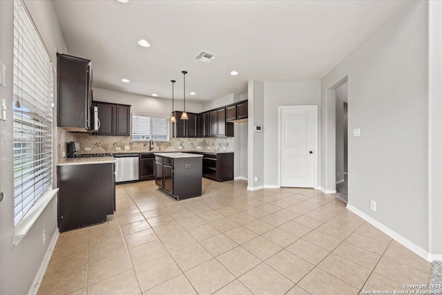 12012 Ivy Post, Schertz, TX 78154 - kitchen with stainless steel appliances, a kitchen island, tasteful backsplash, light countertops, and dark brown cabinetry