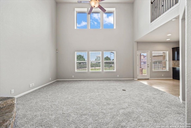 12012 Ivy Post, Schertz, TX 78154 - unfurnished living room featuring carpet flooring, a ceiling fan, baseboards, a towering ceiling, and tile patterned floors