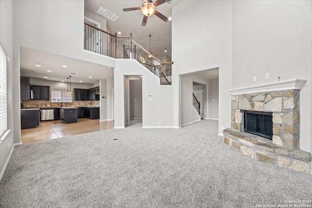 12012 Ivy Post, Schertz, TX 78154 - unfurnished living room with light colored carpet, stairs, ceiling fan, baseboards, and a fireplace