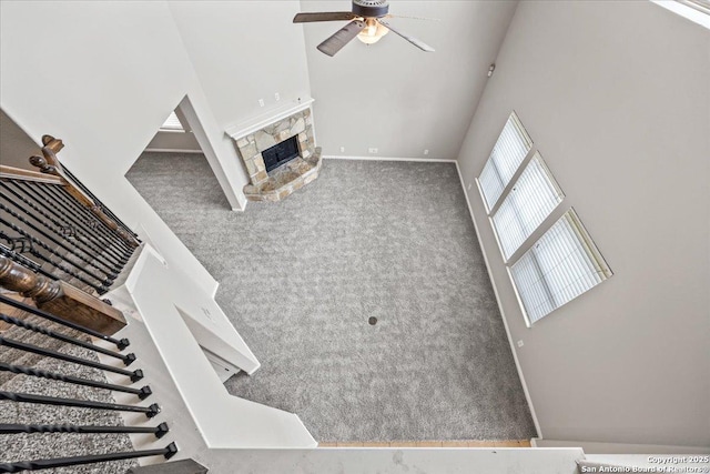 12012 Ivy Post, Schertz, TX 78154 - unfurnished living room featuring ceiling fan, carpet, stairway, and a fireplace