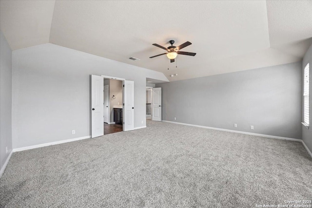 12012 Ivy Post, Schertz, TX 78154 - unfurnished bedroom featuring dark carpet, baseboards, vaulted ceiling, ensuite bath, and a spacious closet