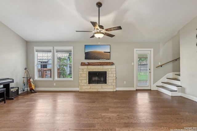 12102 Cherry Blossom, San Antonio, TX 78247 - unfurnished living room with ceiling fan, wood finished floors, a stone fireplace, stairs, and baseboards