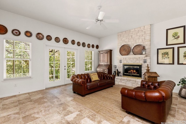 557 Timber Holw, New Braunfels, TX 78132 - living area with a fireplace, a ceiling fan, baseboards, and light stone finish floors