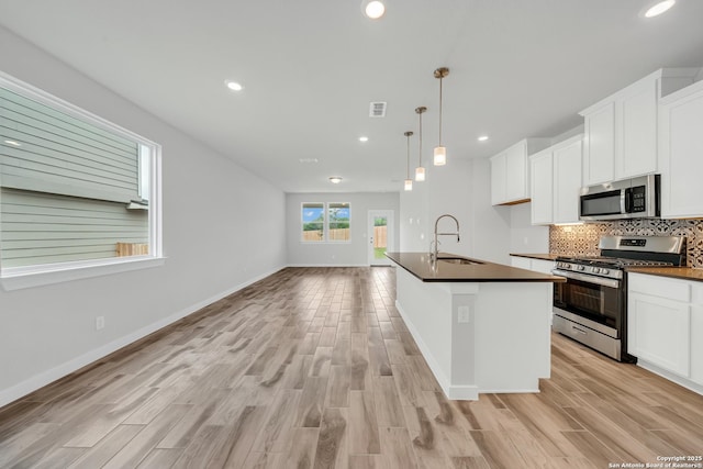 771 Fort Leonard, San Antonio, TX 78245 - kitchen featuring stainless steel appliances, a sink, dark countertops, light wood finished floors, and recessed lighting