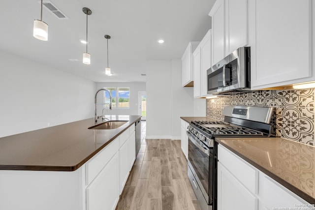 771 Fort Leonard, San Antonio, TX 78245 - kitchen featuring appliances with stainless steel finishes, a sink, light wood-style flooring, decorative backsplash, and white cabinetry