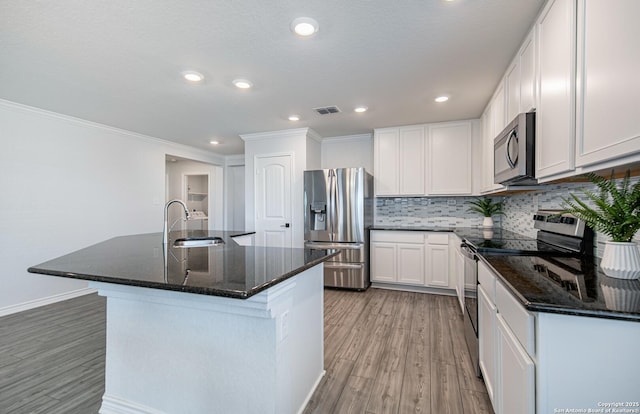 14755 Grey Egret Run, San Antonio, TX 78253 - kitchen with appliances with stainless steel finishes, a sink, light wood-type flooring, crown molding, and decorative backsplash