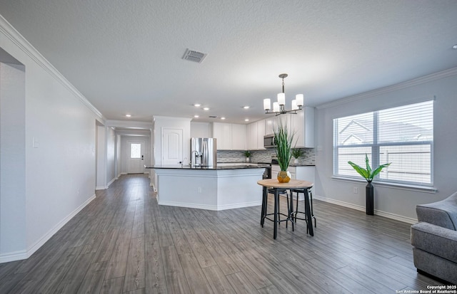 14755 Grey Egret Run, San Antonio, TX 78253 - kitchen featuring dark countertops, open floor plan, a chandelier, appliances with stainless steel finishes, and ornamental molding