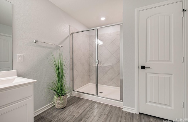 14755 Grey Egret Run, San Antonio, TX 78253 - full bathroom with a stall shower, vanity, wood finished floors, baseboards, and a textured wall